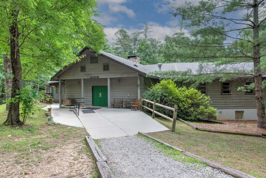 Bischoff Center at Lutheridge, a gray-sided building with a green door at the end of a paved walk