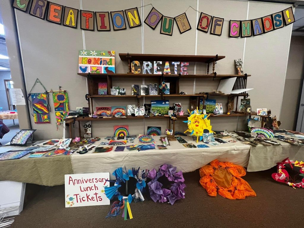 Art from the Create In Me retreat on display under a Creation Out of Chaos banner