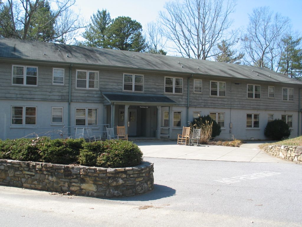 Thornburg Hall at Lutheridge, a two-story gray building with rocking chairs by the entrance