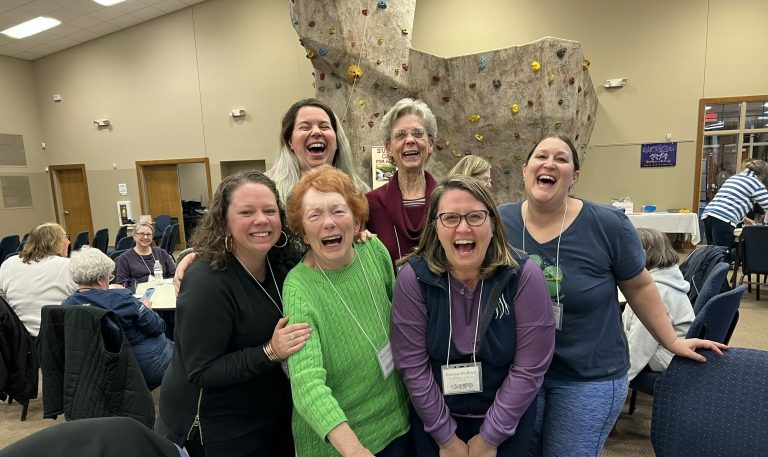 Women laughing together in a group photo at Wild Women Weekend at Lutheridge