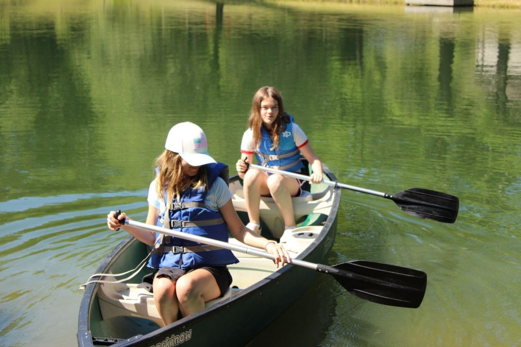Two campers paddling a canoe on the Lutheridge lake
