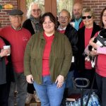 Members of St. Matthew’s Lutheran Church in Jacksonville gather outside their church, one holding a small dog