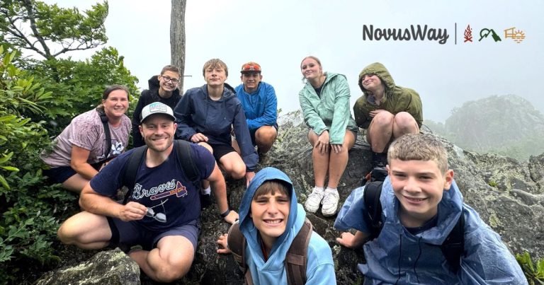 A Lutherock hiking group smiling together on a rocky mountaintop