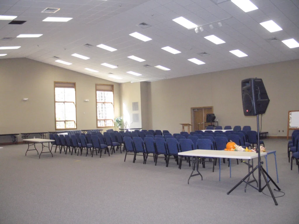 Faith Center's main hall set with rows of chairs, tables and a sound system