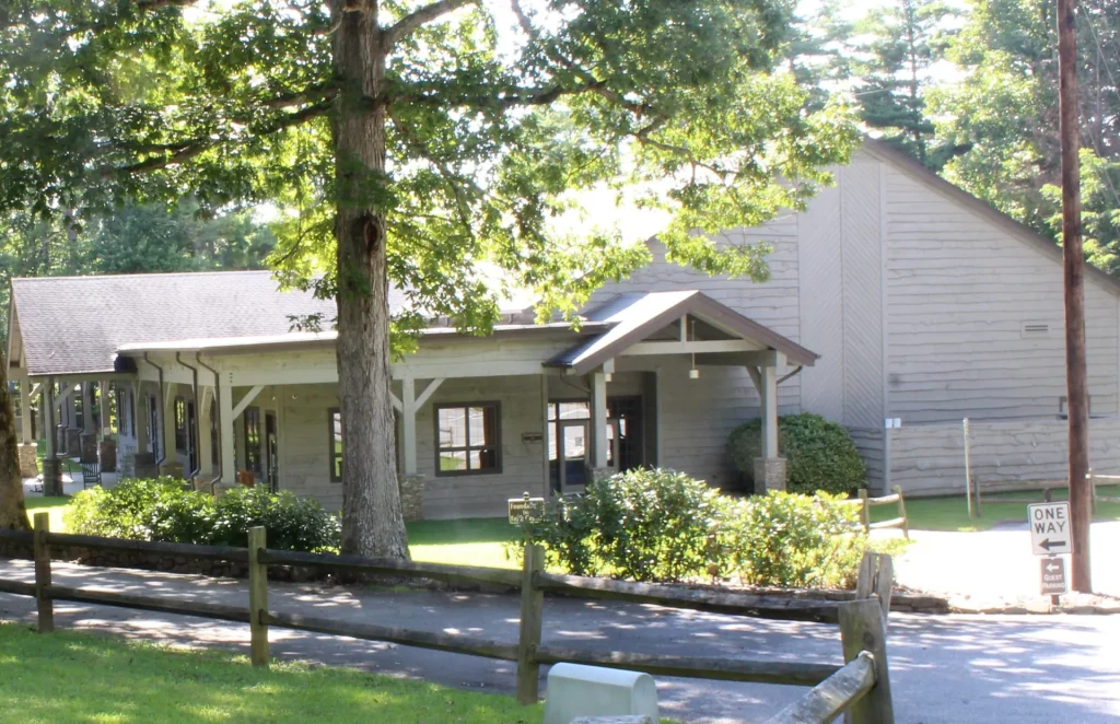 The side of the Faith Center from the path, behind a split-rail fence