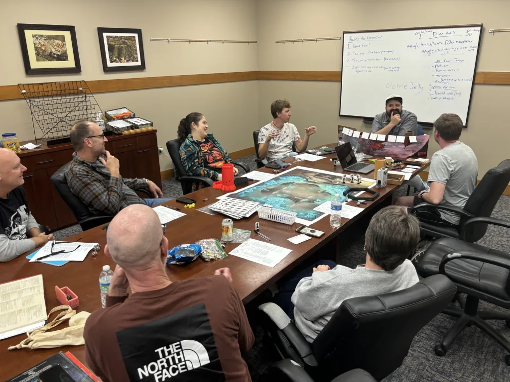 Adults playing a tabletop role-playing game around the board room table in the Faith Center at Lutheridge