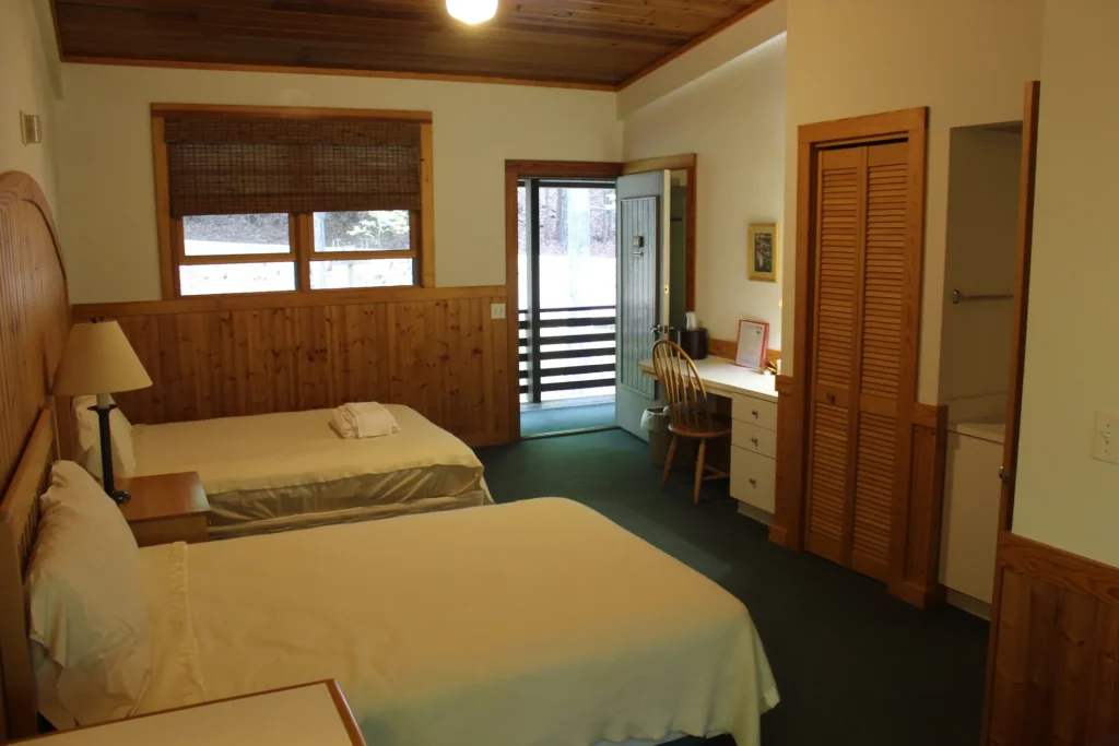 A Kohnjoy Inn guest room with two beds and a door out to the balcony