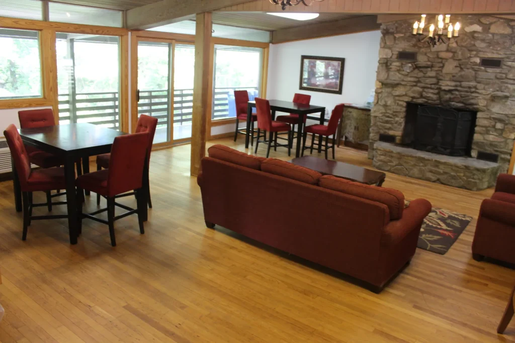 Kohnjoy Inn's lounge: a stone fireplace, sofas and dining tables by the windows