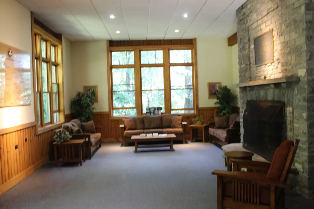 Lineberger's meeting lounge: sofas, a stone fireplace and a wall of windows