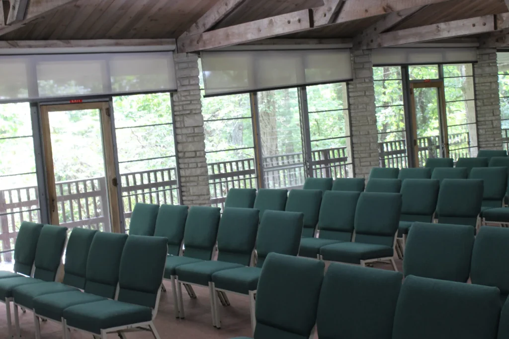 Mission Hall's sunroom set with chairs, windows on three sides