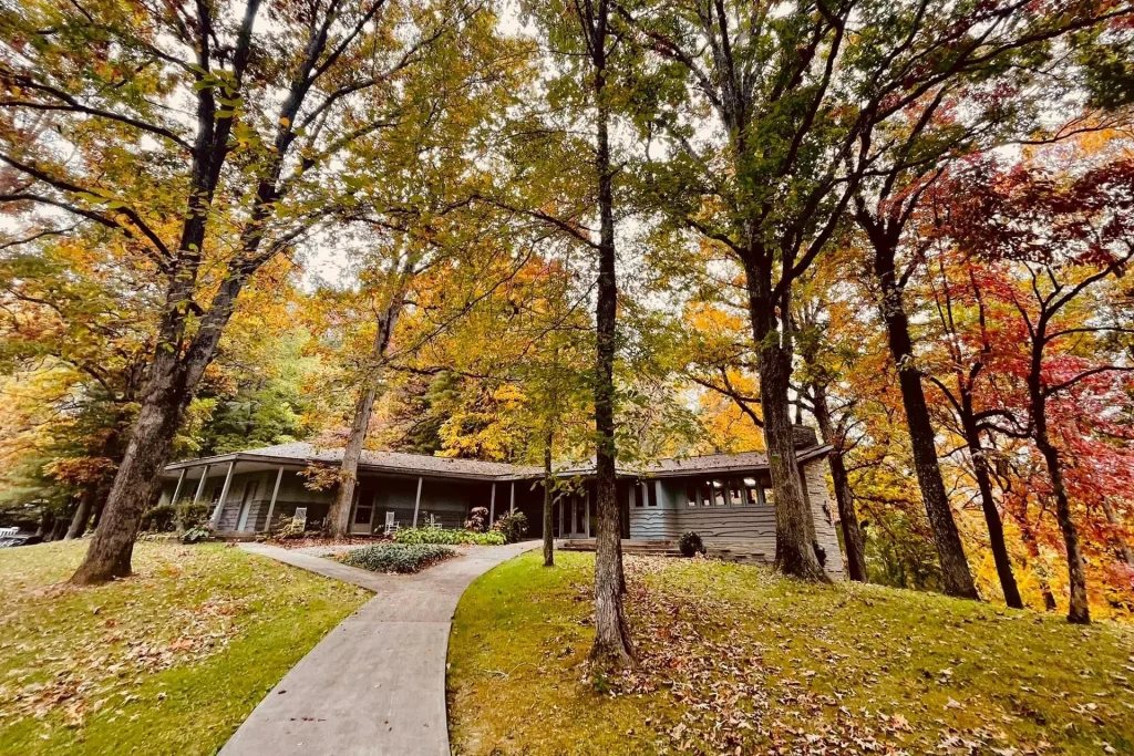 Mission Hall at Lutheridge beneath tall trees in fall color