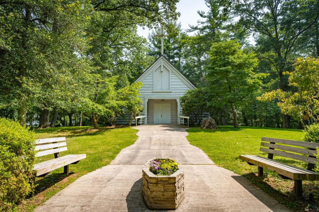A stone path between benches and flowers leading to Whisnant Chapel at Lutheridge