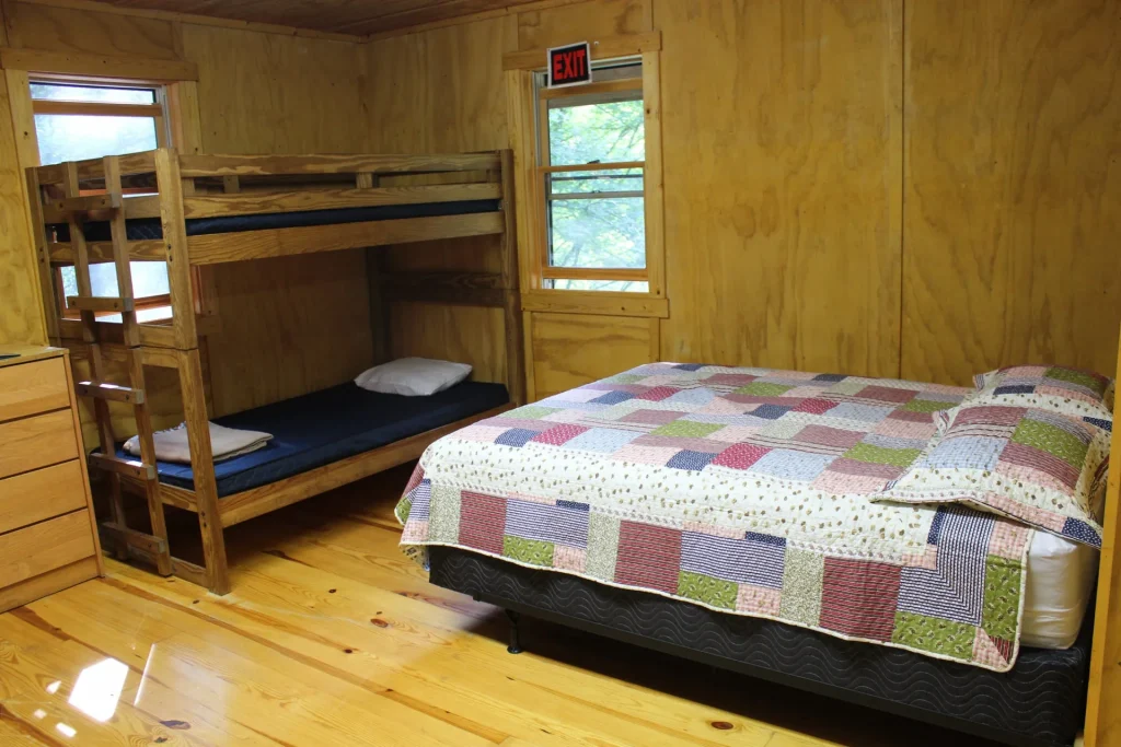 A Cabin Village room with a queen bed and a bunk bed