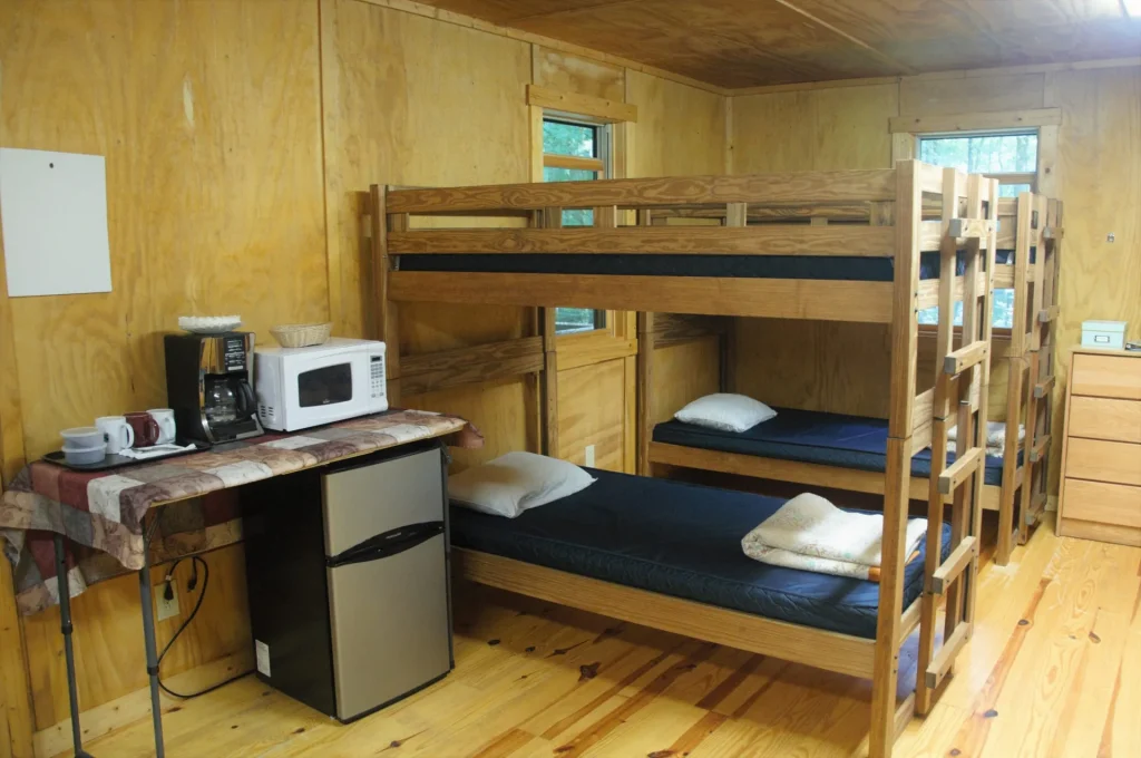 Bunk beds, a desk, microwave and small refrigerator in a Cabin Village cabin