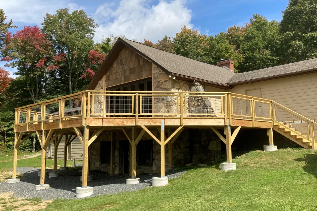 Founders Lodge at Lutherock with its new deck, trees turning color behind it