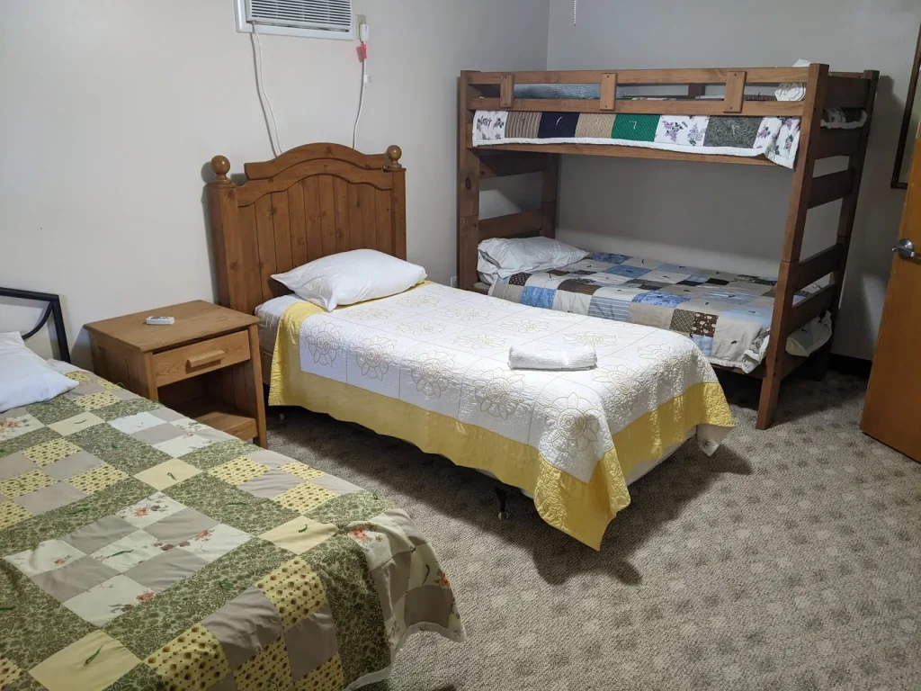 A Kuehner bedroom with a bunk bed and two quilted beds