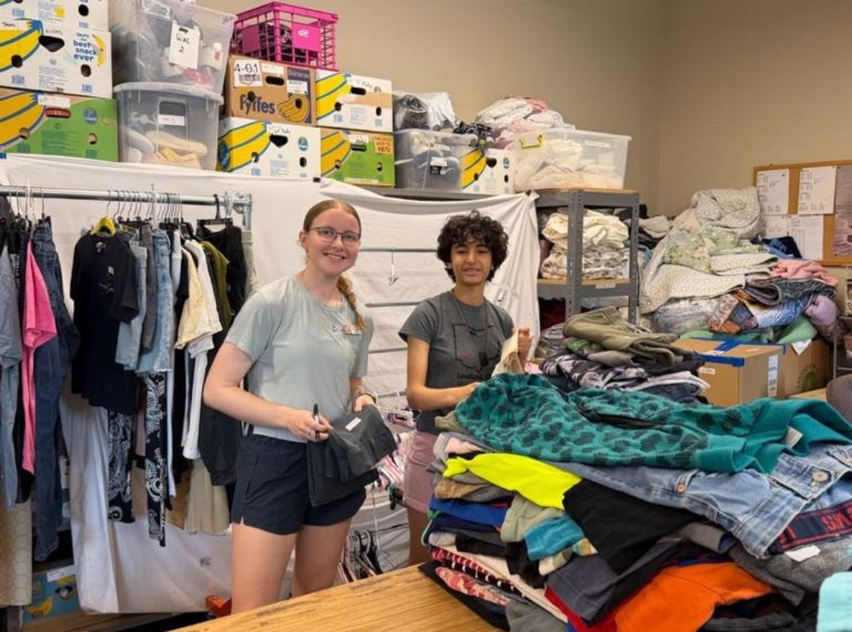 Two volunteers sorting donated clothing during a service week at Lutheridge