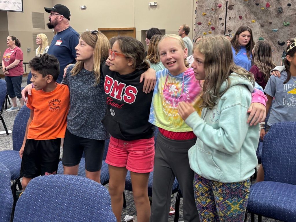 Kairos campers singing arm in arm during worship