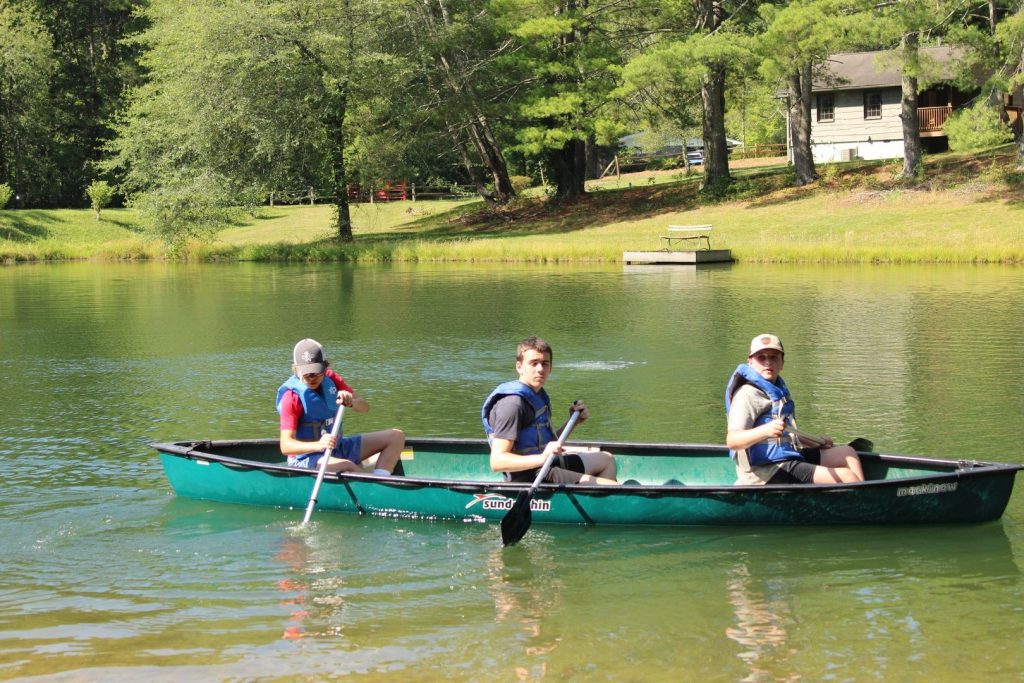 Three River Explorers campers paddling a canoe on the Lutheridge lake