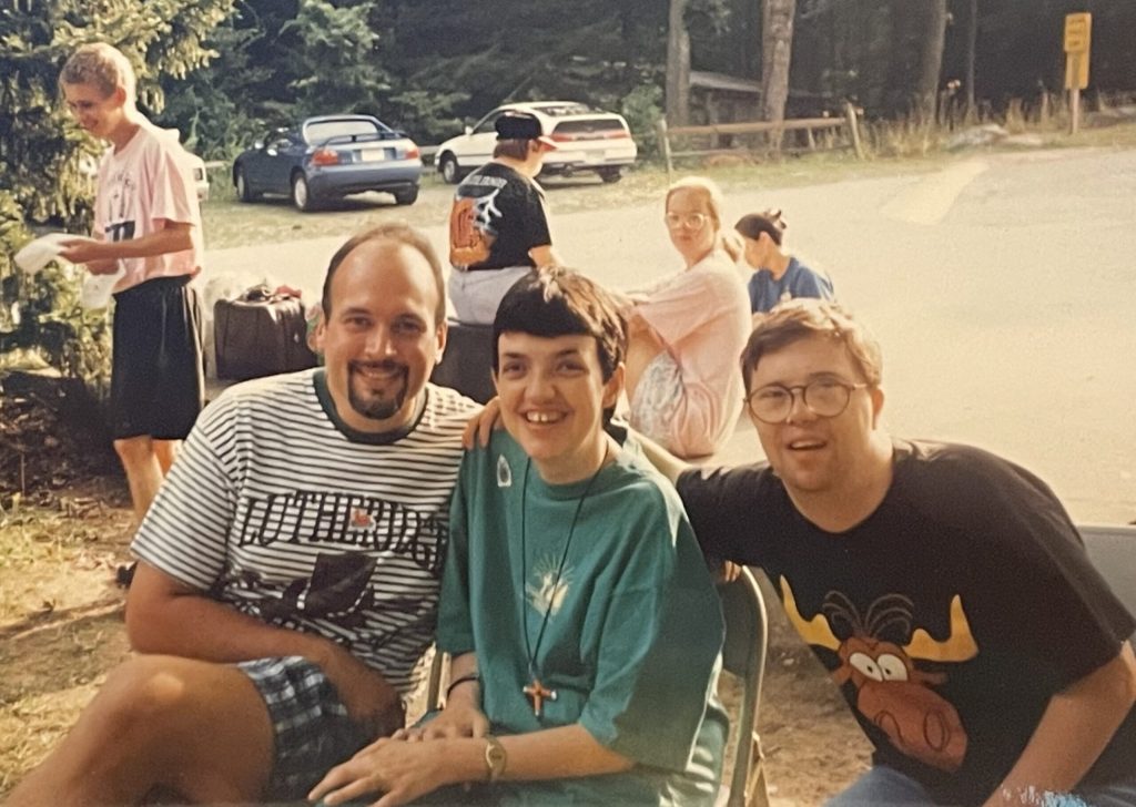 Craig Nelius as a Lutheridge counselor in the early 1990s, smiling beside two campers