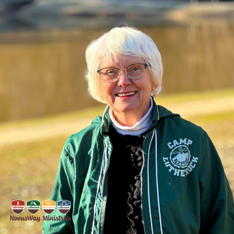 Bea Youngdahl in a green Camp Lutherock jacket, smiling outdoors